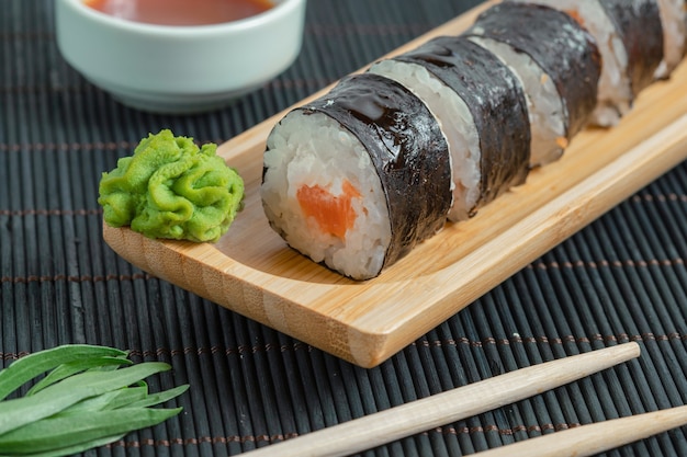 Vista superior de rollos de sushi sobre superficie negra.