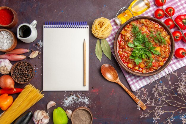 Vista superior sabrosa comida de salsa de verduras cocidas con tomates y condimentos en la comida de plato de comida de salsa de fondo oscuro