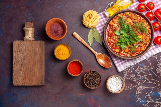 Vista superior sabrosa comida de salsa de verduras cocidas con tomates y condimentos sobre fondo oscuro cena salsa comida plato comida