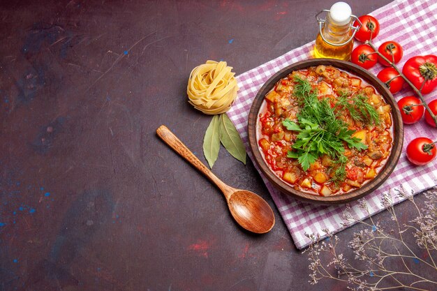 Vista superior sabrosa comida de salsa de verduras cocidas con tomates en el plato de comida de salsa de cena de comida de fondo oscuro