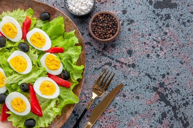 Vista superior sabrosa ensalada de huevo con ensalada verde y aceitunas sobre fondo claro