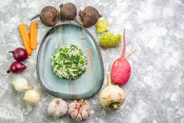 Vista superior sabrosa ensalada de repollo con verduras frescas en mesa blanca