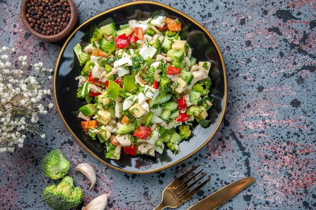 Vista superior sabrosa ensalada de verduras con cubiertos sobre fondo oscuro restaurante de comida color dieta saludable cocina madura