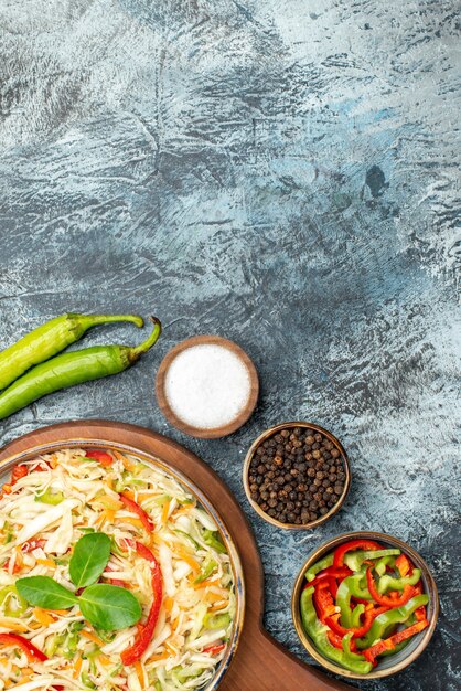 Vista superior de sabrosa ensalada con verduras frescas en superficie oscura