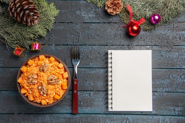 Vista superior sabrosa ensalada de zanahoria con nueces en la dieta de alimentos de color azul oscuro ensalada de escritorio tuerca salud