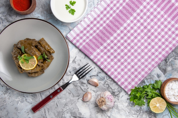 Vista superior de la sabrosa hoja de dolma con ajo sobre superficie blanca