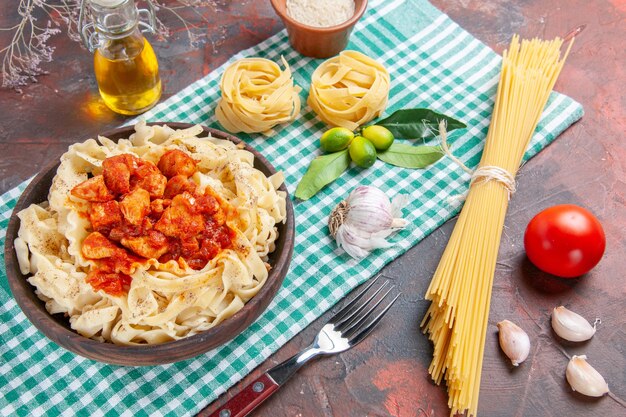 Vista superior de la sabrosa masa cocida con pollo y salsa en un plato de comida de pasta de piso oscuro