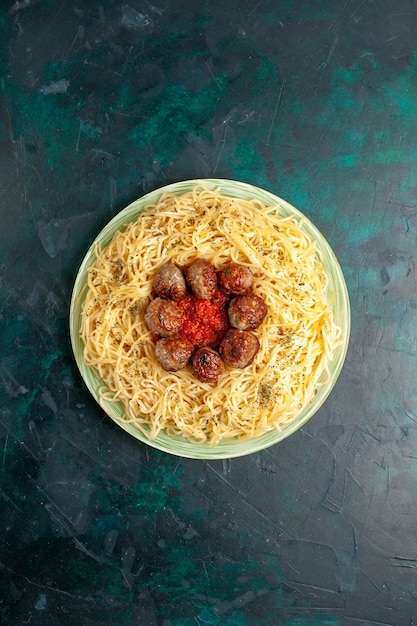 Vista superior sabrosa pasta italiana con albóndigas en el fondo azul oscuro