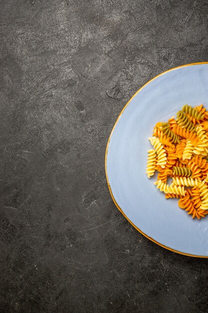 Vista superior sabrosa pasta italiana pasta espiral cocida inusual en la oscuridad