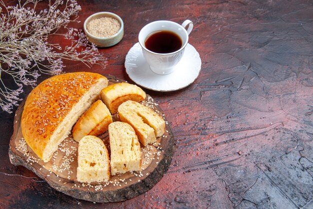 Vista superior de la sabrosa pastelería dulce cortada en trozos con té sobre fondo oscuro