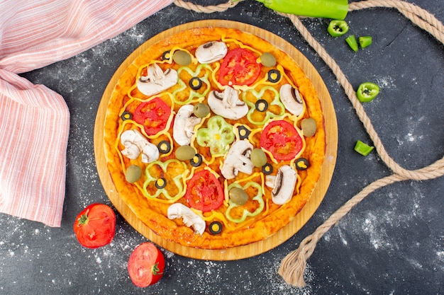 Vista superior sabrosa pizza de champiñones con tomates rojos aceitunas champiñones con tomates frescos por todo el escritorio gris masa de pizza italiana