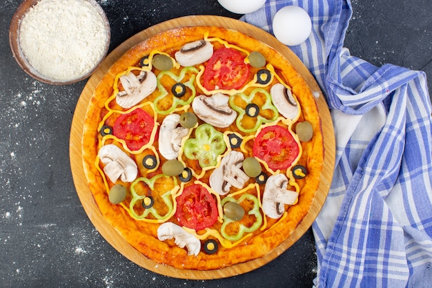 Vista superior sabrosa pizza de champiñones con tomates rojos pimientos aceitunas y champiñones, todos en rodajas por dentro con huevos en la masa de pizza de comida de escritorio oscuro