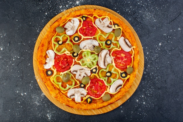 Vista superior sabrosa pizza de champiñones con tomates rojos, pimientos, aceitunas y champiñones, todos en rodajas en el interior del escritorio gris comida pizza italiana