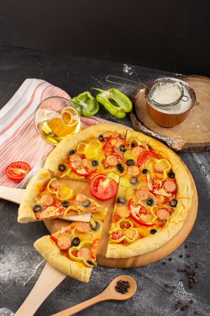 Vista superior de la sabrosa pizza con queso con tomates rojos, aceitunas negras y salchichas en el escritorio oscuro con aceite y tomates frescos, comida rápida, masa italiana para hornear