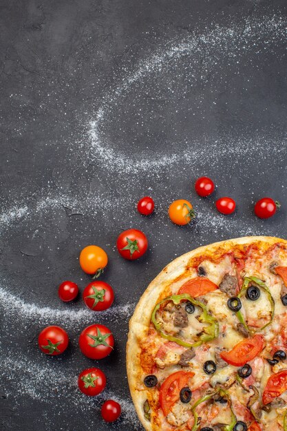 Vista superior sabrosa pizza de queso con tomates rojos sobre superficie oscura
