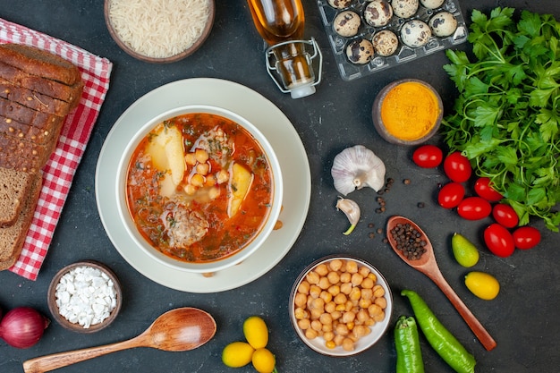 Vista superior sabrosa sopa de carne consiste en patatas, carne y frijoles sobre fondo oscuro