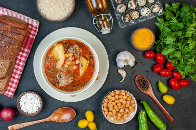 Vista superior sabrosa sopa de carne consiste en patatas, carne y frijoles sobre fondo oscuro