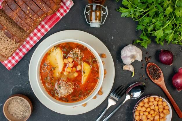 Vista superior sabrosa sopa de carne consiste en patatas, carne y frijoles sobre fondo oscuro