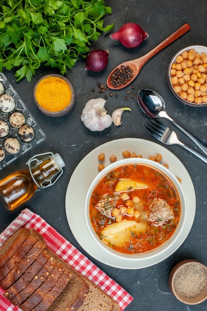 Vista superior sabrosa sopa de carne consiste en patatas, carne y frijoles sobre fondo oscuro