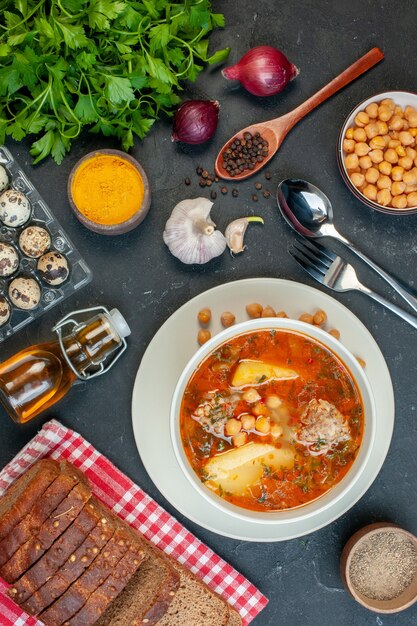 Vista superior sabrosa sopa de carne consiste en patatas, carne y frijoles sobre fondo oscuro