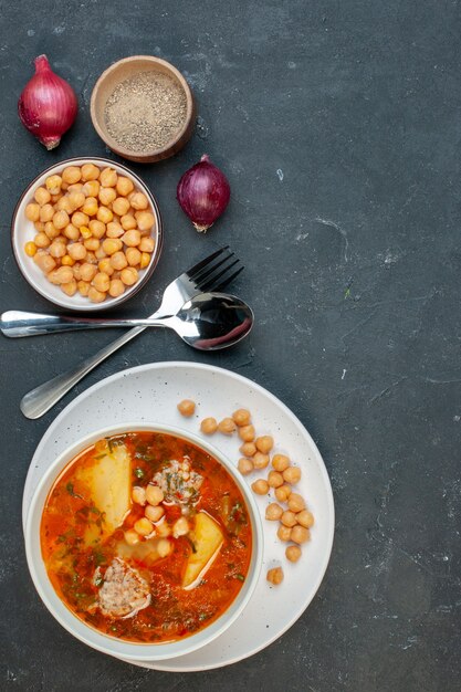 Vista superior sabrosa sopa de carne consiste en patatas, carne y frijoles sobre fondo oscuro