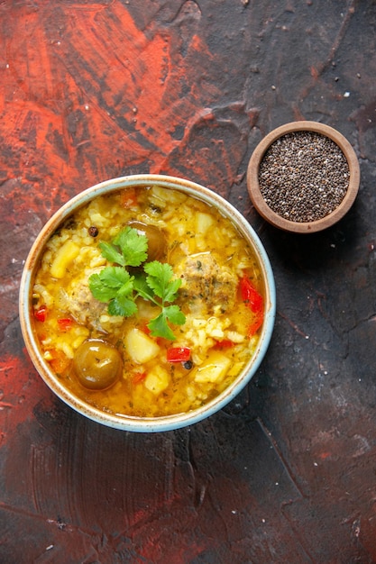 Vista superior sabrosa sopa de carne con patatas y arroz dentro de un plato pequeño sobre una superficie oscura