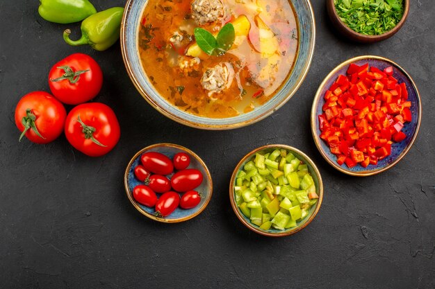 Vista superior sabrosa sopa de carne con verduras frescas en un plato de color de foto de comida de mesa oscura