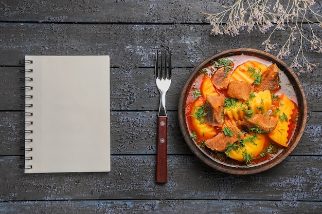 Vista superior sabrosa sopa de carne con verduras y patatas en el escritorio oscuro