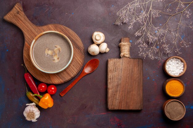 Vista superior sabrosa sopa de champiñones con diferentes condimentos en el escritorio oscuro sopa de hongos condimento comida comida