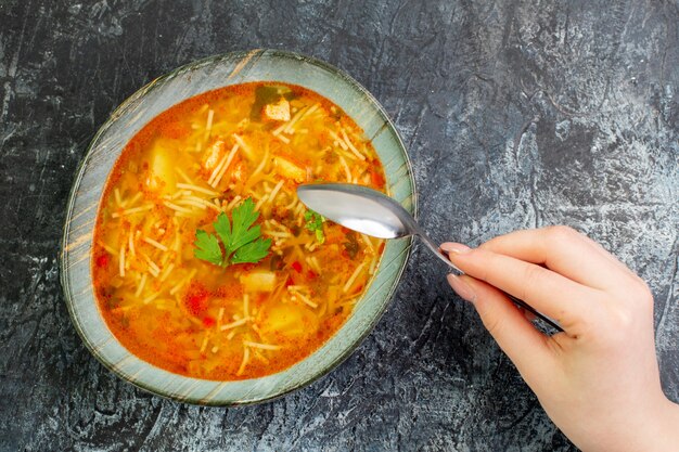 Vista superior sabrosa sopa de fideos dentro de la placa en la mesa de luz