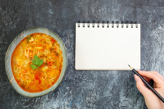 Vista superior sabrosa sopa de fideos dentro del plato sobre la mesa gris claro