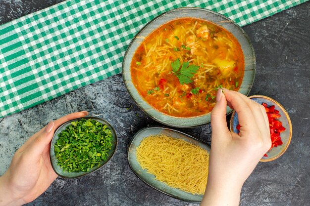 Vista superior sabrosa sopa de fideos con verduras en la mesa gris claro