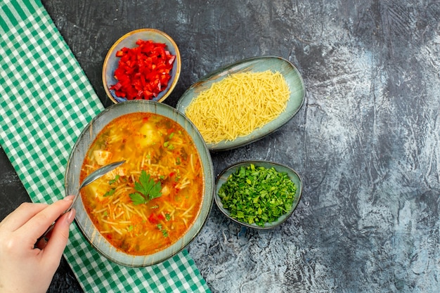 Vista superior sabrosa sopa de fideos con verduras en la mesa gris claro