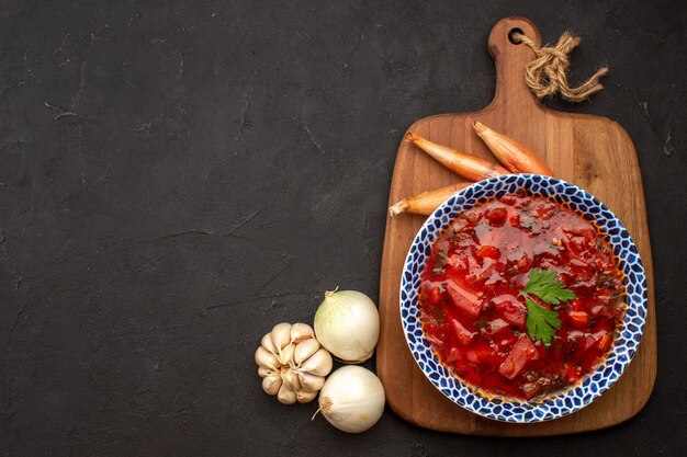 Vista superior sabrosa sopa de remolacha ucraniana borsch con ajo en el espacio oscuro