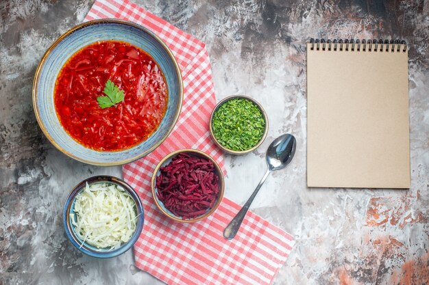 Vista superior de la sabrosa sopa de remolacha ucraniana borsch dentro de la placa en la superficie blanca