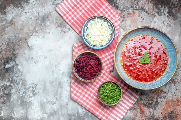 Vista superior de la sabrosa sopa de remolacha ucraniana borsch dentro de la placa en la superficie blanca