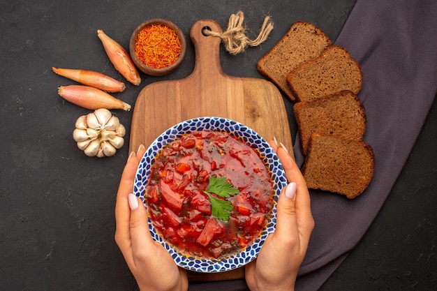 Foto gratuita vista superior sabrosa sopa de remolacha ucraniana borsch con panes de pan oscuro en el espacio oscuro