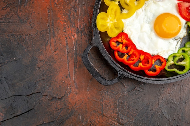 Vista superior sabrosa tortilla con rodajas de pimientos y tomates en la mesa oscura escuela huevos revueltos desayuno matutino té color pan lugar libre