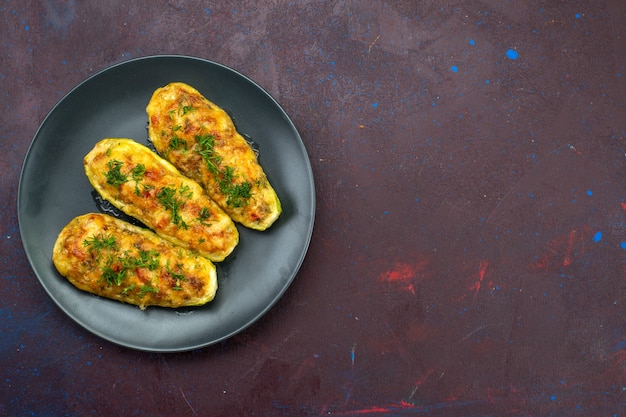 Foto gratuita vista superior de sabrosas calabazas al horno con verduras dentro de la placa sobre la superficie oscura