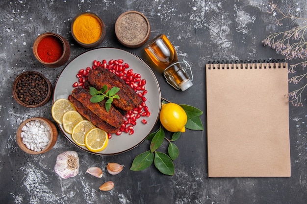 Vista superior sabrosas chuletas de carne con condimentos en la comida de la foto del plato de fondo gris