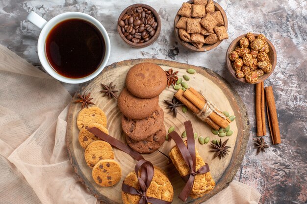 Vista superior sabrosas galletas dulces con taza de café en la mesa de luz