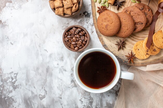 Vista superior sabrosas galletas dulces con taza de café en la mesa de luz