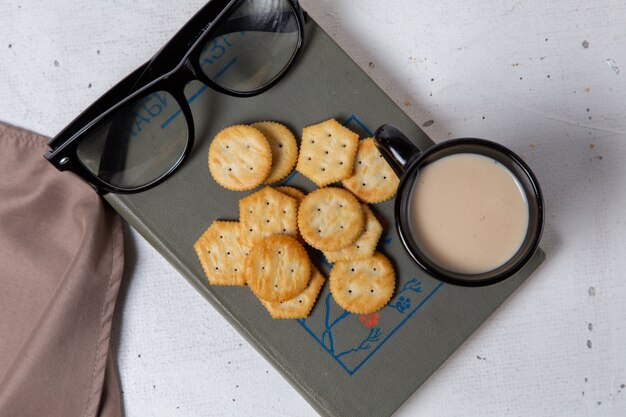 Vista superior sabrosas patatas fritas con leche y gafas de sol en el refrigerio de la foto de la galleta crujiente de fondo claro