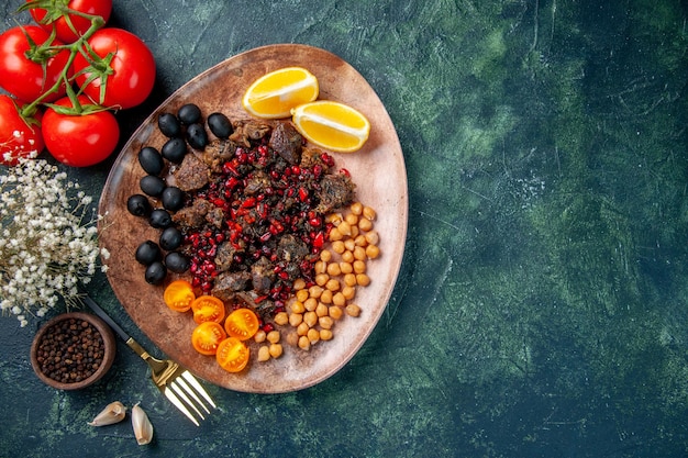 Vista superior sabrosas rebanadas de carne frita con frijoles uvas y rodajas de limón dentro de la placa, comida plato comida