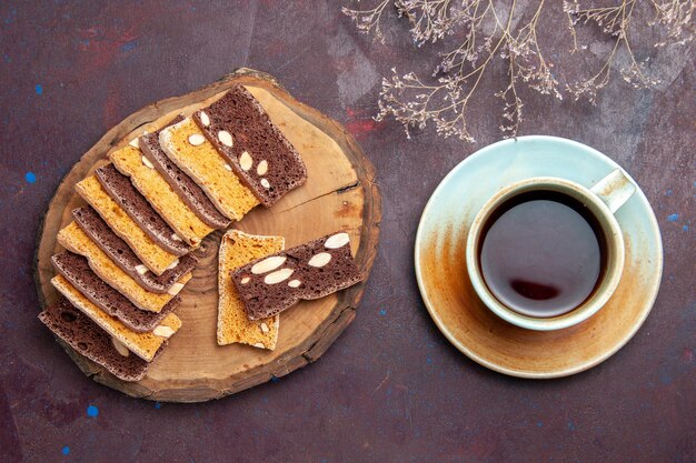 Vista superior de sabrosas rebanadas de pastel con nueces y taza de té en negro