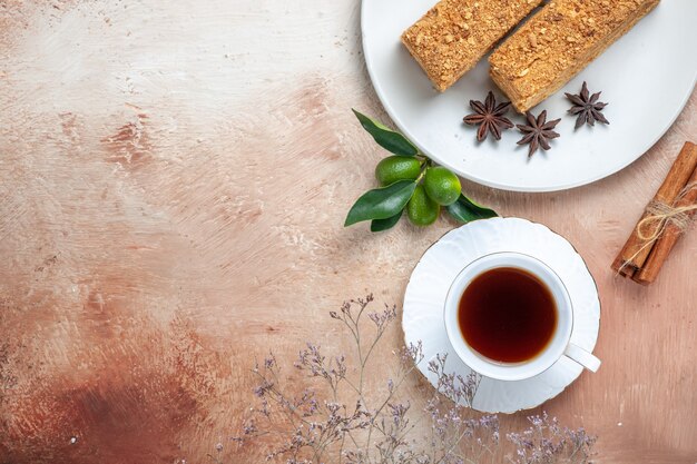 Vista superior de sabrosas rebanadas de pastel con taza de té en la luz