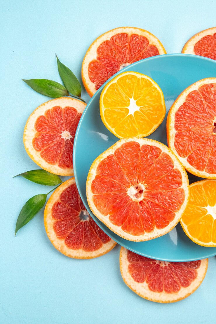 Foto gratuito vista superior de sabrosas rodajas de fruta de pomelos en la superficie azul