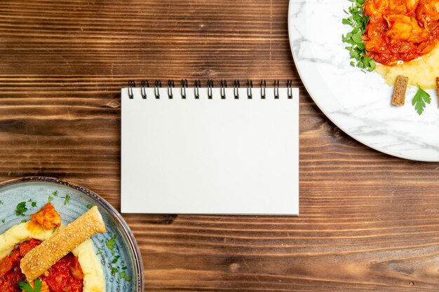 Vista superior de sabrosas rodajas de pollo con puré de patatas en mesa de madera marrón