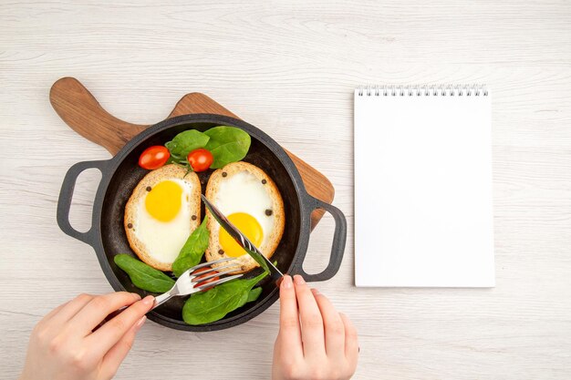 Vista superior sabrosas tostadas de huevo comiendo por mujer sobre fondo blanco comida plato de ensalada pan color comida té almuerzo desayuno