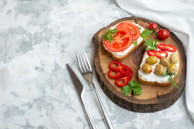 Vista superior sabrosas tostadas con tomates y aceitunas en tablero de madera fondo blanco pan hamburguesa merienda cena sándwich horizontal comida almuerzo